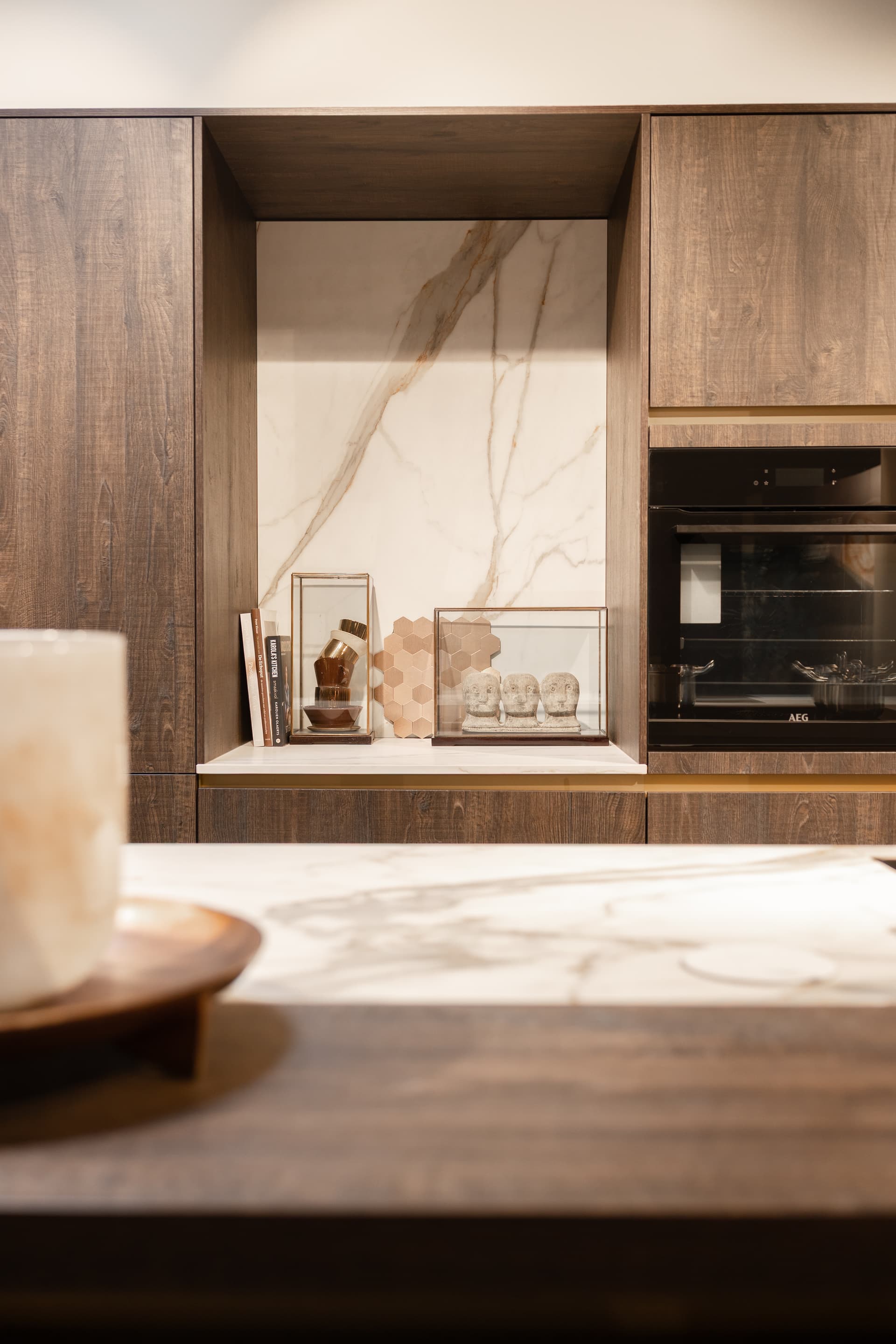 Donkerhouten keuken met beige marmer werkblad en keukenwand