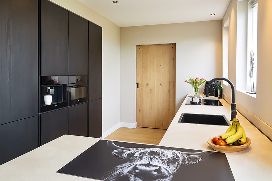 Moderne-keuken-met-schiereiland-en-hoge-kastenwand.jpg