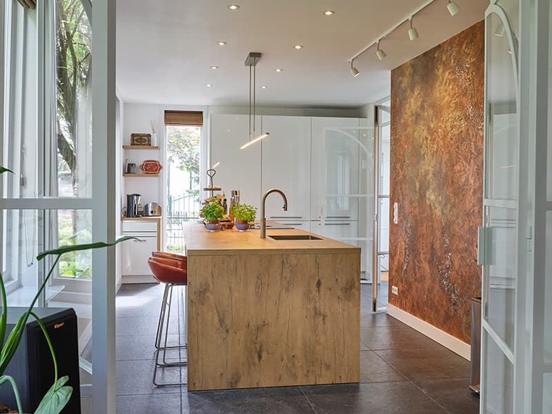 Houten-eilandkeuken-met-kastenwand-en-witte-fronten