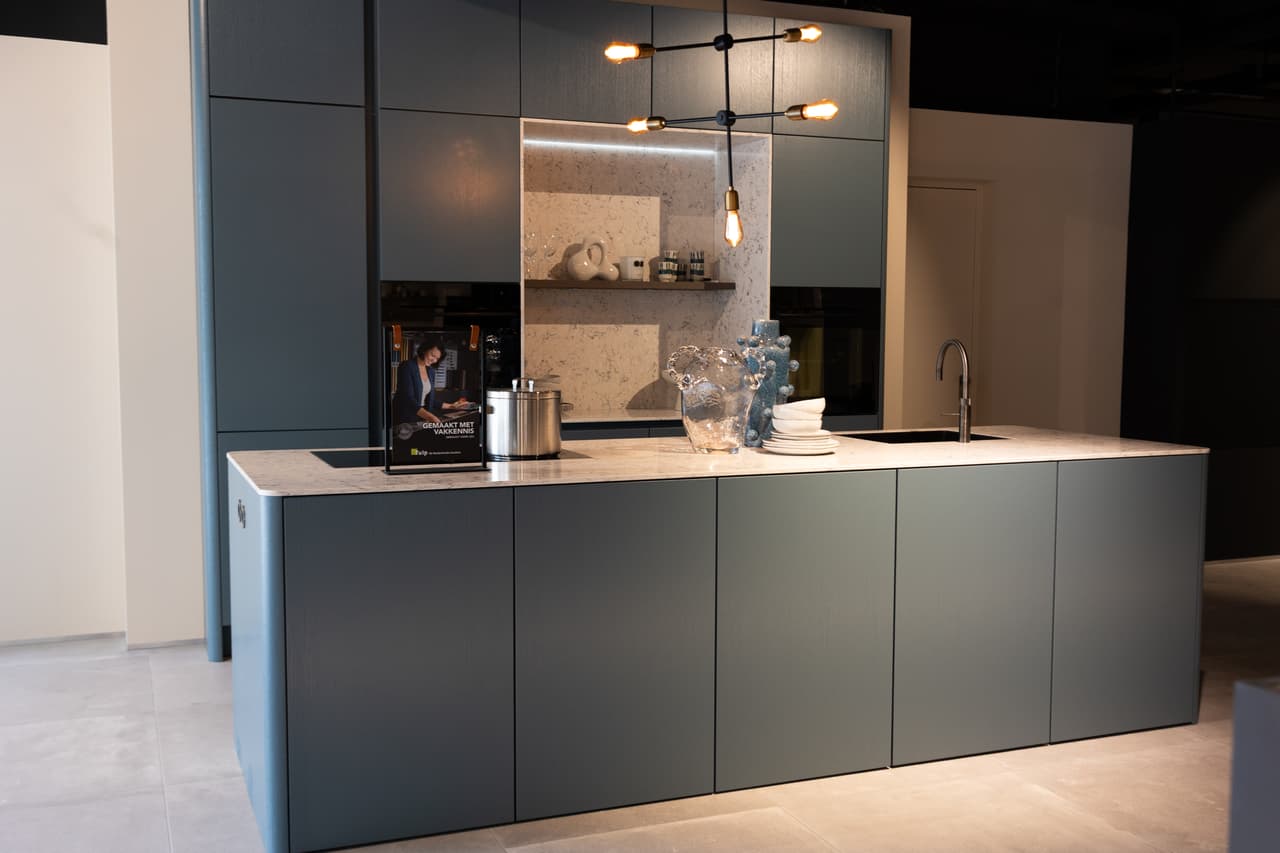 TULP overzichten-3.jpg Blauwe keuken met hoge kasten en een kookeiland met een beige marmer werkblad