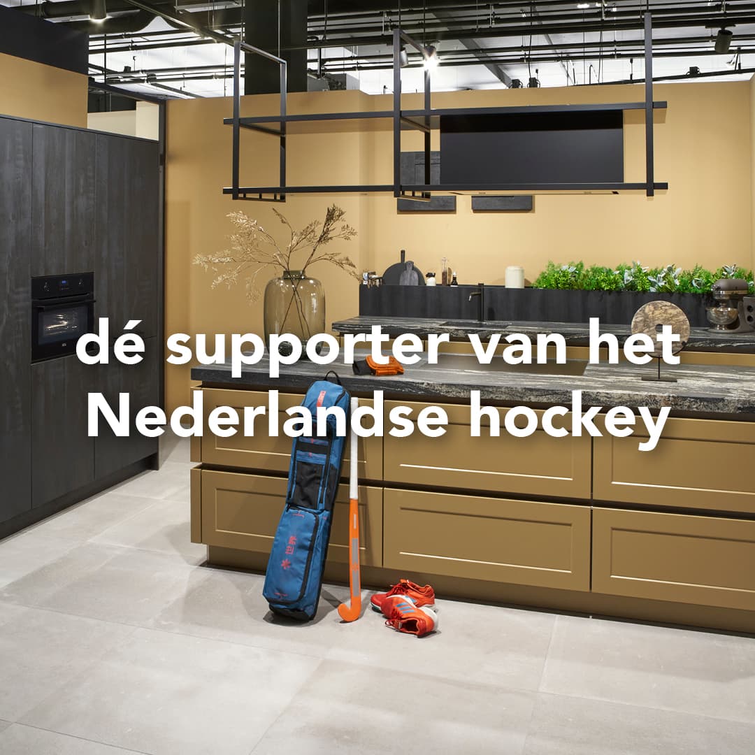 Bruine keuken met marmer blad en kookeiland waar een hockeystick met tas tegenaan staat