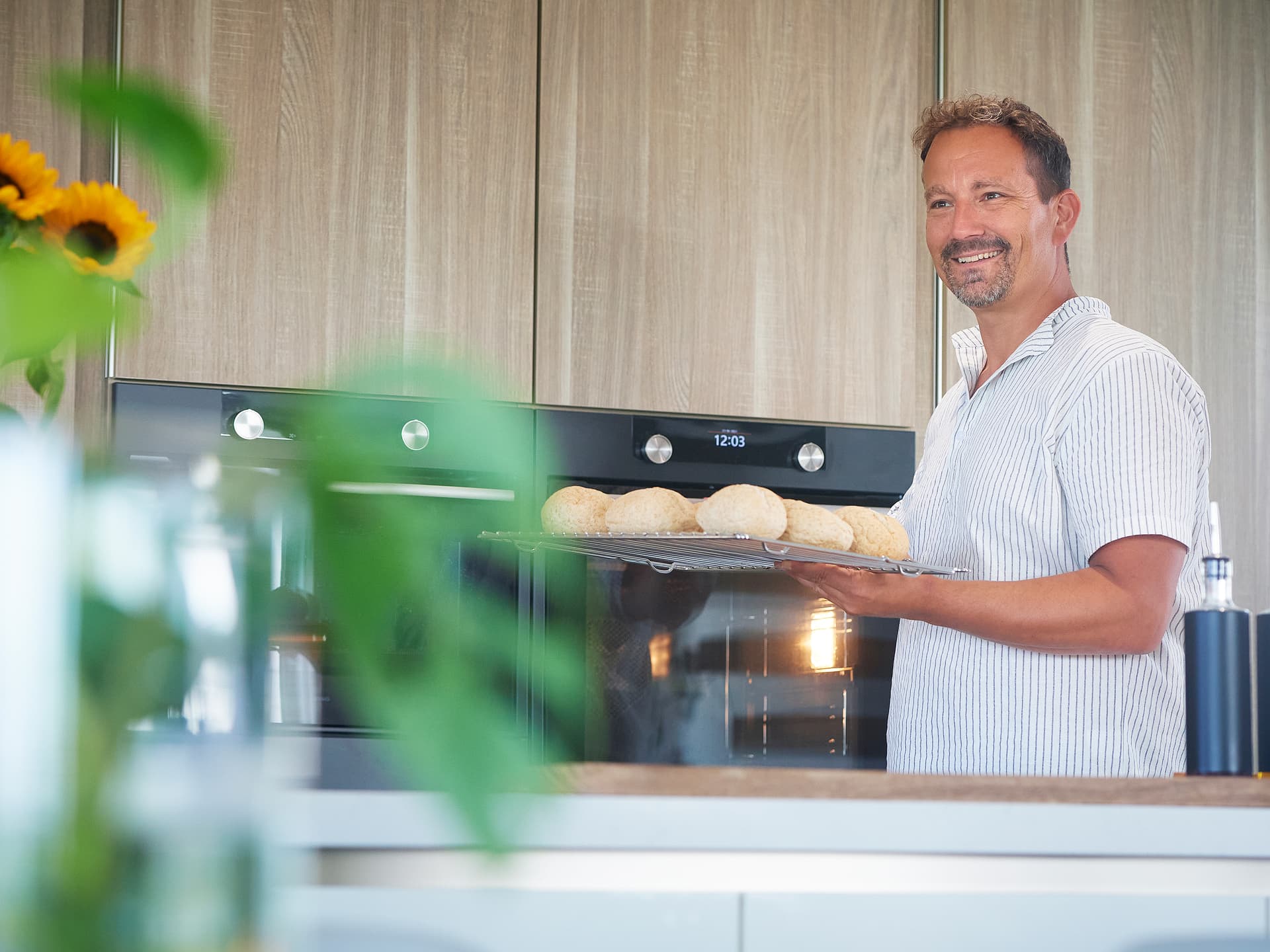 Man-die-gebruikmaakt-van-ovens-in-keuken.jpg Man die gebruikmaakt van ovens
