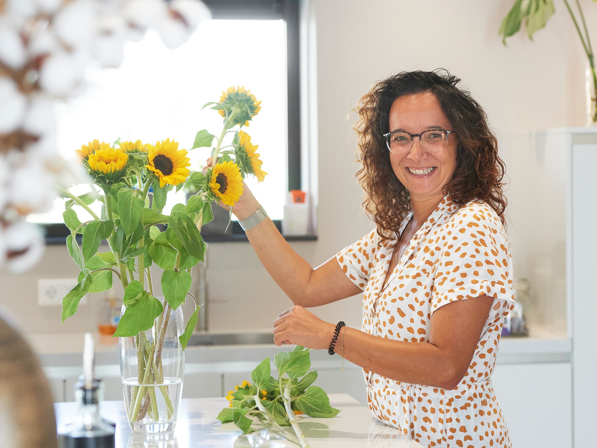 Vrouw-die-bloemen-schikt-in-keuken.jpg Vrouw die bloemen schikt